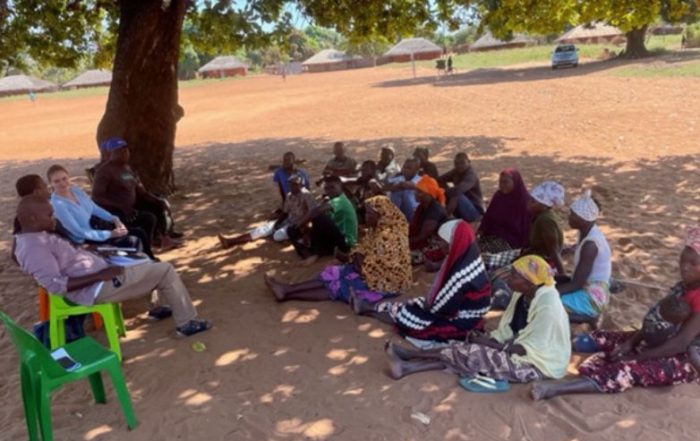 group of people sitting underneath a tree